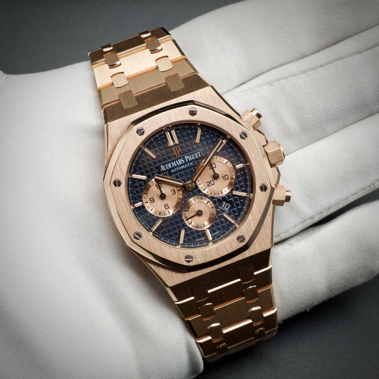 Audemars Piguet with rose gold case and blue dial held in hand